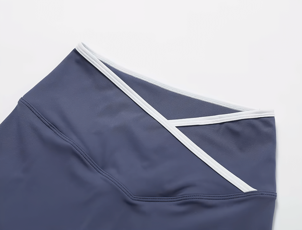 Close-up of stylish high-waist flared yoga pants in navy blue with white trim, showcasing the elastic waistband design.